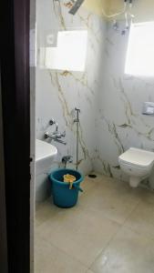 a bathroom with a toilet and a tub next to a sink at Goldan inn yercaud in Yercaud