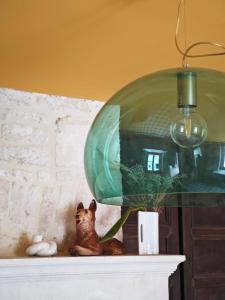 a cat figurine sitting on a shelf with a glass lamp at Domaine du Moulin Français in Champougny +82 photos