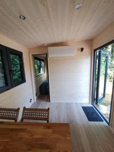 ein Raum mit zwei Bänken und einer Wand mit Fenstern in der Unterkunft Tiny House in Weismes