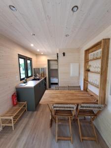 ein Raum mit einem Holztisch und Stühlen in einer Küche in der Unterkunft Tiny House in Weismes