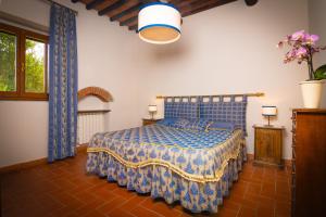 a bedroom with a bed with a blue comforter at Agriturismo Castello Di Querceto in Lucolena in Chianti
