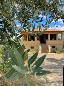 a house with a building in the background at L’ Aia del Principe in Montepulciano