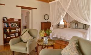 a bedroom with a bed and two chairs and a table at De Hoop Collection in De Hoop Nature Reserve