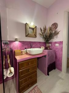 a bathroom with a sink and a purple wall at House Hermosa Barrabisa in Barrabisa