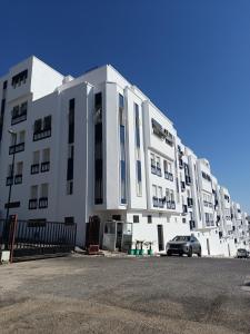 a large white building with a car parked in front at Dar hicham in Hajreien