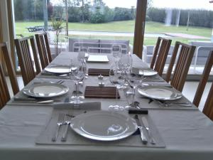 a table with plates and wine glasses on it at Monte Girassol - The Lisbon Country House! in Quinta das Faias