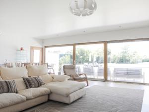 a living room with a white couch and a large window at Monte Girassol - The Lisbon Country House! in Quinta das Faias