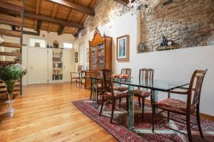 a dining room with a glass table and chairs at Palazzo Benassi Penthouse nel cuore di Asolo in Asolo