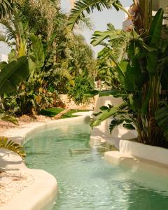 a swimming pool in a resort with green plants at RIVELIAN Grand Menorca in Menorca