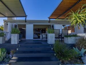 a house with a porch with chairs and a patio at Palmview Cottage in Cape Town
