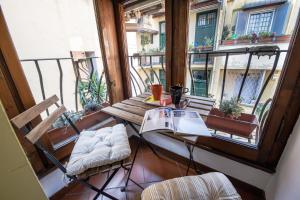 a balcony with a table and chairs and a book at Lo Chalet di Trastevere in Rome