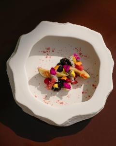 a white bowl filled with food on a table at RIVELIAN Grand Menorca in Menorca +34 photos