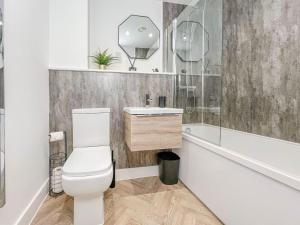 a bathroom with a toilet and a sink and a tub at Copper Suite - 2Bed Elegance - Parking in Liverpool