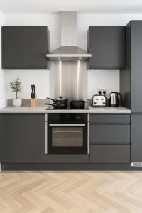 a kitchen with a stove and a counter top at Copper Suite - 2Bed Elegance - Parking in Liverpool