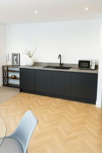 a kitchen with a sink and a microwave at Copper Suite - 2Bed Elegance - Parking in Liverpool +3 photos