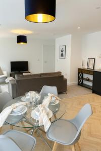 a living room with a glass table and chairs at Copper Suite - 2Bed Elegance - Parking in Liverpool