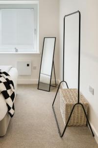 a bedroom with two mirrors and a wicker stool at Copper Suite - 2Bed Elegance - Parking in Liverpool