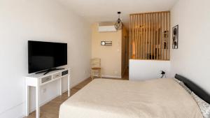 a bedroom with a bed and a flat screen tv at Beau Regard in Tournus