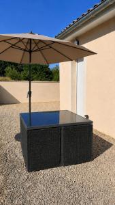 a table with an umbrella on top of gravel at Beau Regard in Tournus