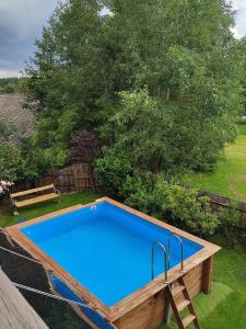 a large swimming pool in a yard with a bench at Da Tizzi in Trahütten