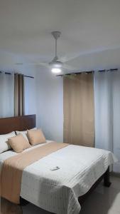 a bedroom with a large bed with white sheets at condominio Crismairy in Bayahibe