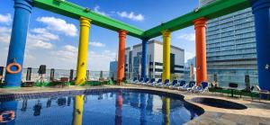 a swimming pool with chairs and a building at Oryx Hotel in Abu Dhabi