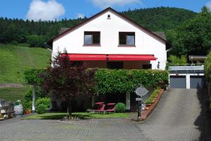 a white house with chairs and a driveway at Haus Grünewald in Zell an der Mosel