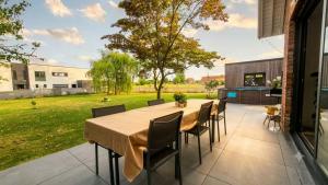 a patio with a wooden table and chairs at Le Bosquet-Villa Prestige, Parking privé, Jardin, Wifi in Lys-lès-Lannoy