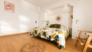 a bedroom with a bed with a floral bedspread at Le Bosquet-Villa Prestige, Parking privé, Jardin, Wifi in Lys-lès-Lannoy