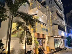 a building with a palm tree in front of it at La Paradise Residency - TIE Hotels in Pondicherry