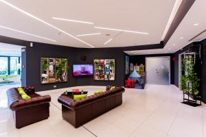 a living room with two couches and a tv at AN Hotel Milano Melegnano in Carpiano