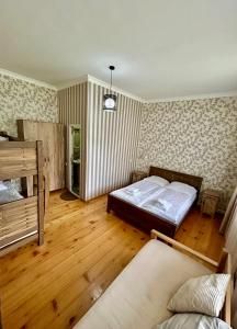 a bedroom with a bed and a wooden floor at Hill House in Kazbegi