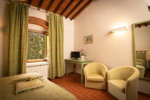 a bedroom with a bed and a desk and a window at Agriturismo Castello Di Querceto in Lucolena in Chianti