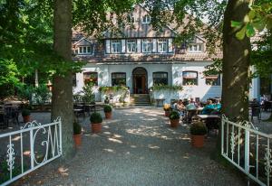 un grupo de personas sentadas en mesas frente a un edificio en Hotel Münnich, en Münster