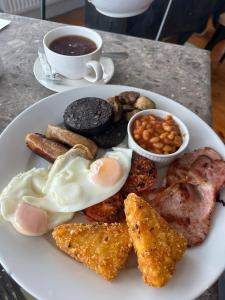 a plate of breakfast food on a table with a cup of coffee at Moorside Hotel and Cafe in Stoupe Brow