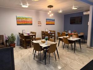 a restaurant with tables and chairs and paintings on the wall at Afrilodge Liberia in Monrovia