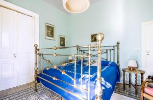 a bedroom with a bed with a blue comforter at Dimora Storica Villa Pietralunga in Nicosia