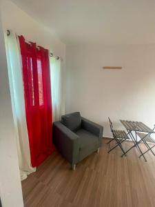 a living room with a chair and a red wall at Rubera - Refúgios & Sabores in Nora