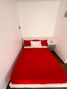a red bed in a small room with a red blanket at Rubera - Refúgios & Sabores in Nora