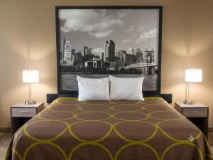 a bedroom with a bed with two lamps and a picture at Super 8 by Wyndham Harrison OH in Harrison +39 photos