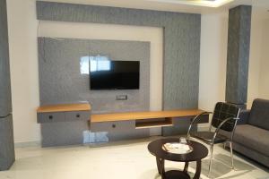 a living room with a tv on a wall at Shri Prasad Executive in Pandharpur +21 photos