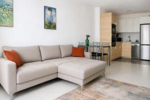 a living room with a couch and a kitchen at Seguro Spacious apartment with roomy terrace, newly renovated in Puerto de Santiago
