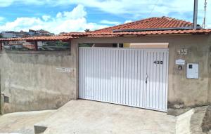 a garage with a white door on a house at Casa próxima ao Parque das Águas in São Lourenço +45 photos
