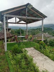 a pavilion with a table and chairs in a garden at Guest house TASO in K'veda Gordi