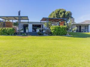 a house with a lawn in front of it at Driftwood beach house in Cape Town +1 photo