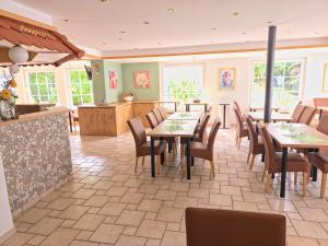 a restaurant with tables and chairs and a kitchen at Hotel zum Kreuzberg in Winterberg