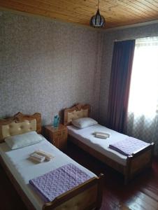 two beds sitting in a room with a window at Guest house TASO in K'veda Gordi