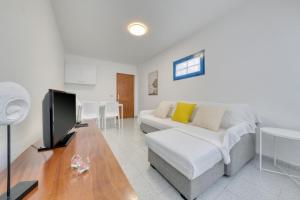 a living room with a couch and a tv at Casa Suso y Casa Margarita- Orzola Coastal Retreat by LVH in Órzola