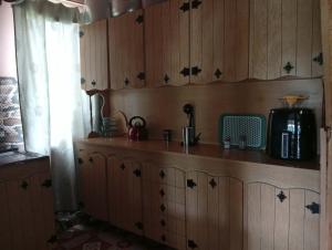a kitchen with wooden cabinets and a counter top at Guest house TASO in K'veda Gordi +19 photos