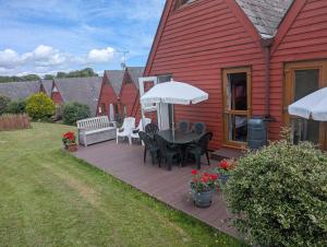 a patio with a table and chairs on a house at Chalet 68 in Kingsdown
